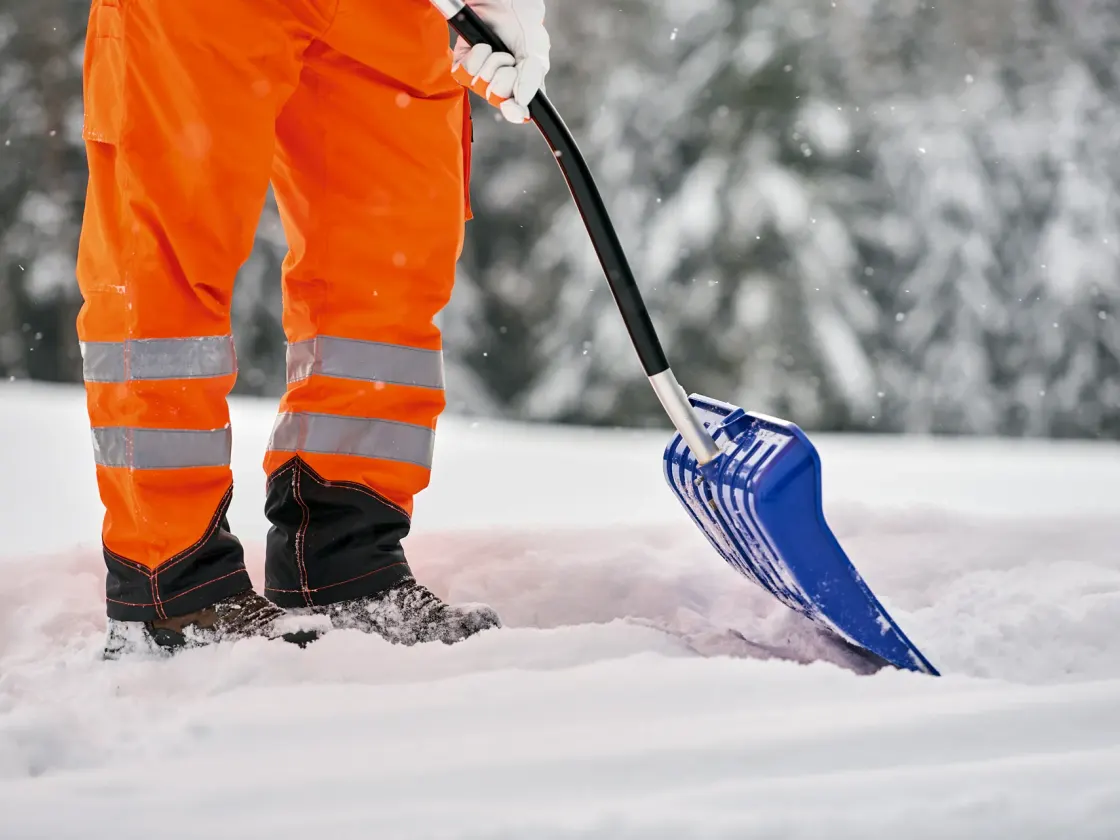 Professioneller Winterdienst beim Räumen einer gewerblich genutzten Fläche