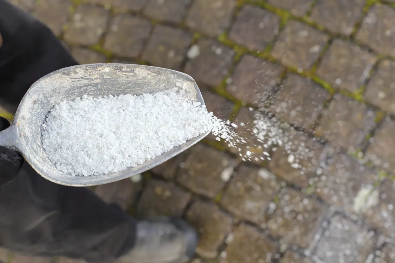 Streugut wird auf einer gepflasterten Fläche für den Winterdienst ausgebracht